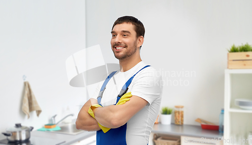 Image of happy male worker or cleaner in gloves at kitchen