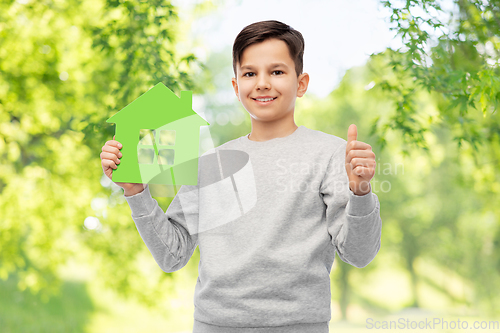 Image of smiling boy with green house and showing thumbs up