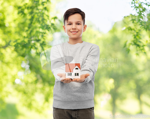 Image of smiling boy holding house model