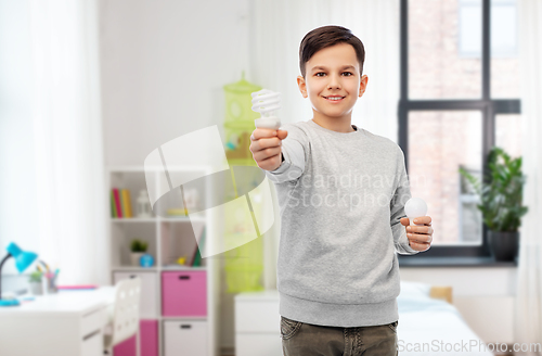 Image of happy boy comparing different light bulbs at home