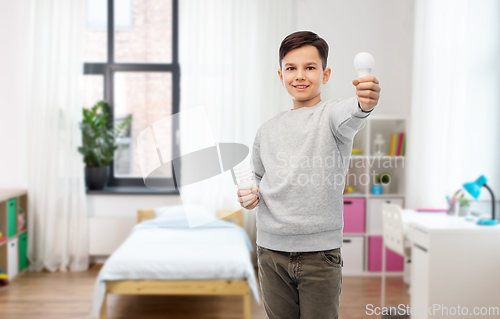 Image of happy boy comparing different light bulbs at home