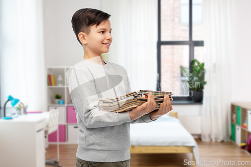 Image of smiling boy with magazines sorting paper waste