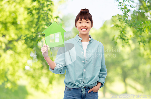 Image of smiling asian woman holding green house