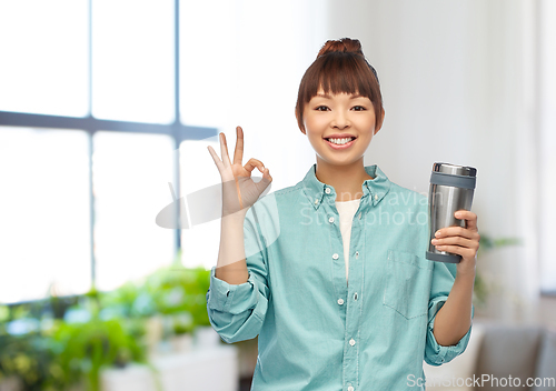 Image of woman with thermo cup or tumbler showing ok sign