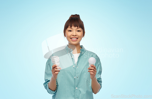 Image of asian woman holding energy saving lighting bulb