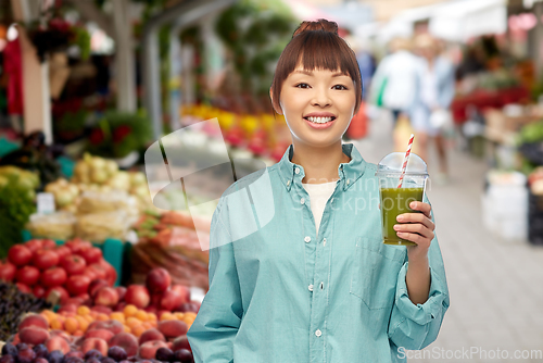 Image of happy asian woman with drink at street market