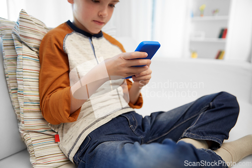 Image of close up of boy with smartphone at home