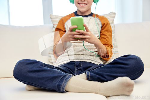 Image of boy with headphones and smartphone at home