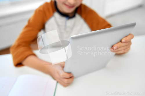 Image of student boy with tablet computer learning at home