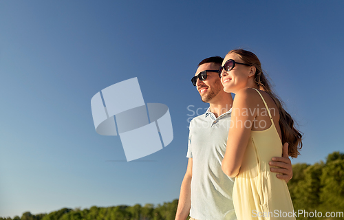 Image of happy couple hugging outdoors in summer