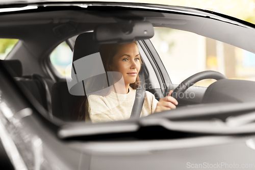 Image of woman or female driver driving car in city