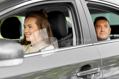 Image of female driver driving car with male passenger