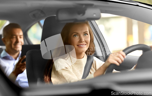 Image of female driver driving car with male passenger