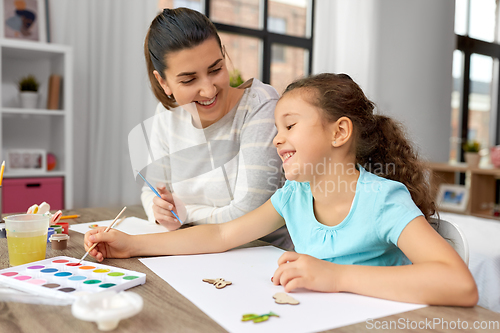 Image of happy mother with little daughter drawing at home