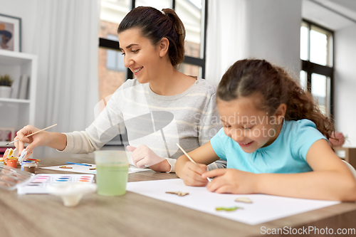 Image of happy mother with little daughter drawing at home