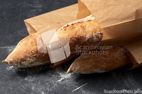 Image of close up of baguette bread in paper bags on table