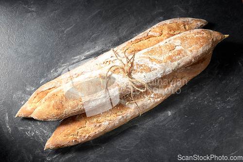 Image of pile of baguette bread loaves tied with rope