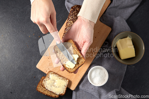 Image of female baker spreading butter on homemade bread