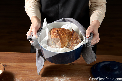 Image of female baker with homemade bread at bakery