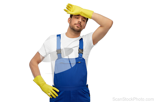 Image of tired male worker or cleaner in overall and gloves