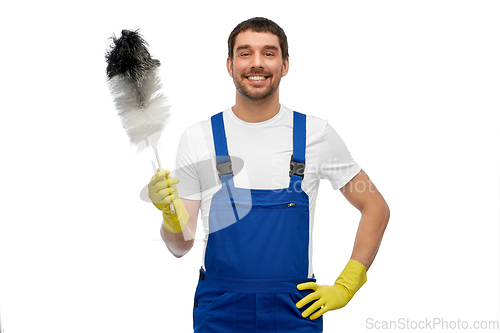 Image of happy male worker or cleaner with duster cleaning