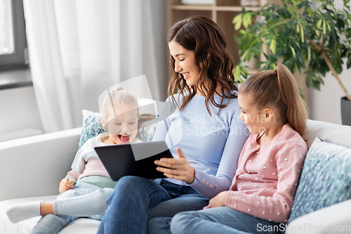 Image of happy mother and daughters with tablet pc at home