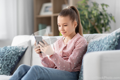 Image of happy smiling little girl with smartphone at home