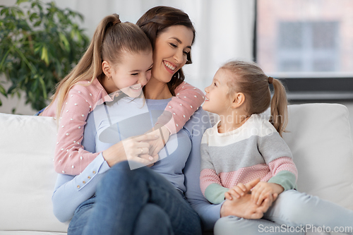 Image of happy smiling mother with two daughters at home