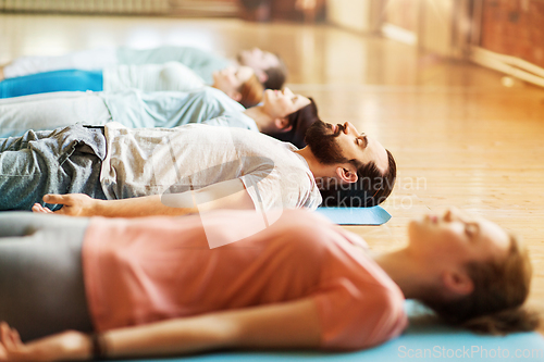 Image of group of people making yoga exercises at studio