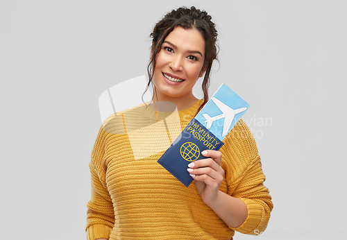 Image of happy woman with air ticket and immunity passport