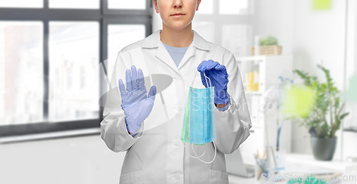 Image of female doctor with two masks showing stop gesture