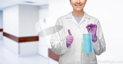 Image of smiling doctor with two masks showing thumbs up