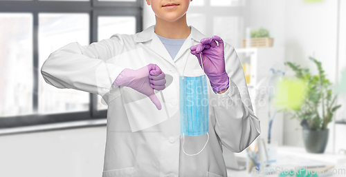 Image of female doctor with mask showing thumbs down