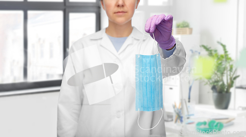 Image of female doctor in gloves showing medical mask