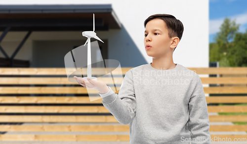 Image of boy with toy wind turbine over house background