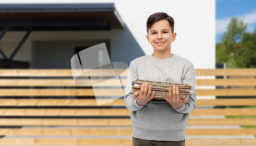Image of smiling boy with magazines sorting paper waste