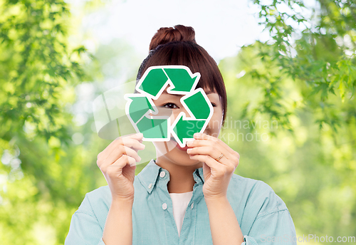 Image of smiling asian woman holding green recycling sign