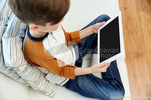 Image of close up of boy with tablet pc computer at home