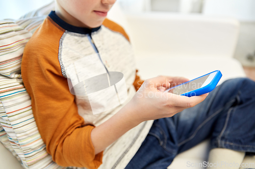 Image of close up of boy with smartphone at home