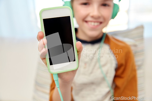 Image of boy with headphones and smartphone at home