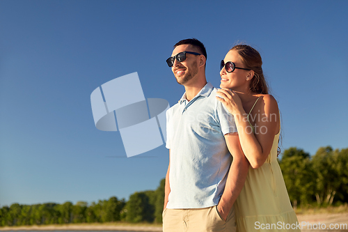 Image of happy couple hugging on summer beach