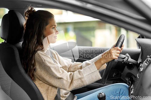 Image of woman or female driver driving car in city