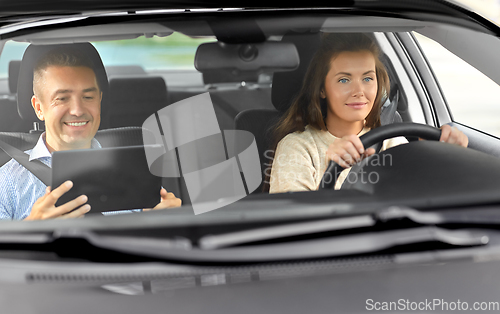 Image of woman and driving school instructor talking in car