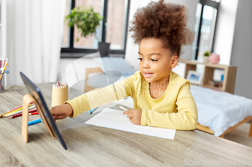 Image of little african girl with tablet pc drawing at home