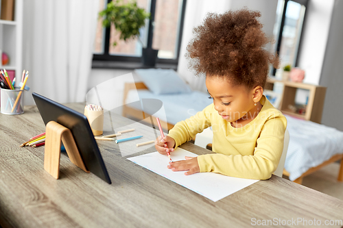 Image of little girl drawing with coloring pencils at home