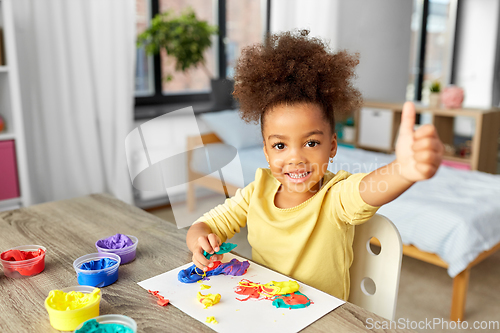 Image of little girl with modeling clay playing at home