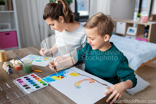 Image of mother and son with colors drawing at home