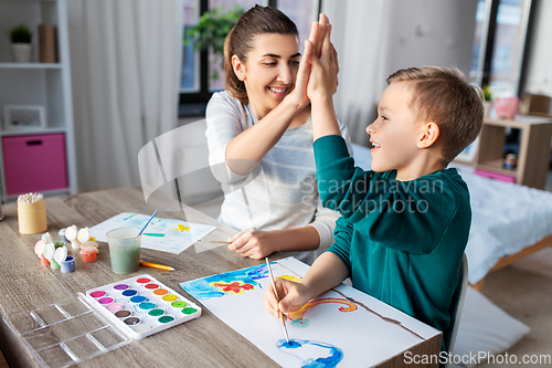 Image of mother and son with colors drawing at home