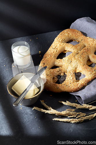 Image of close up of cheese bread, butter, knife and milk