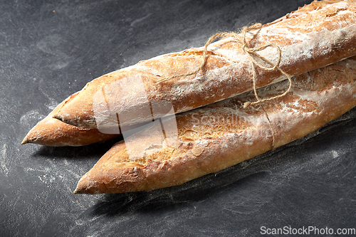 Image of pile of baguette bread loaves tied with rope